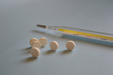 background for a medical website or article, pills and mercury thermometer on a blue background,...