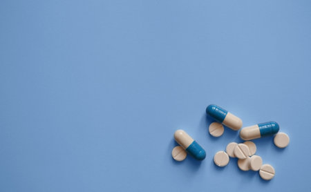 capsules and tablets on a blue background, photos for a medical website, medicines, medical care, a banner for a medical clinic, a place for textの写真素材
