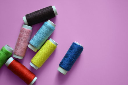 spools of thread on a pink background, a banner for an atelier, tailoring, sewing threads, photos for a textile factoryの写真素材