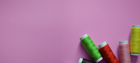 spools of thread on a pink background, a banner for an atelier, tailoring, a photo for a sewing...
