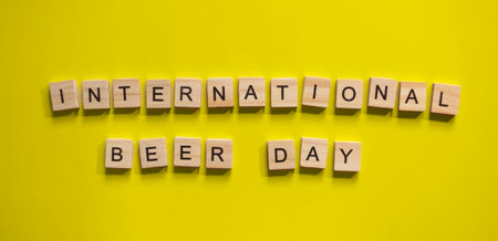 August 4, International Beer Day, minimalistic banner with the inscription in wooden letters on a yellow backgroundの写真素材