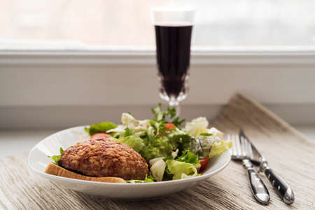 Beef cutlet with salad and wineの写真素材
