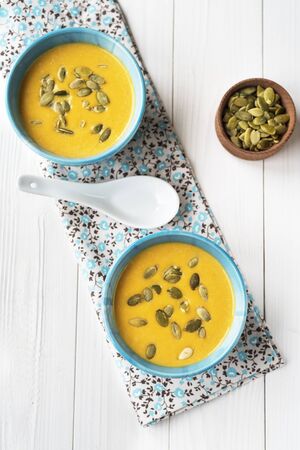 Pumpkin cream-soup on a wood backgroundの写真素材