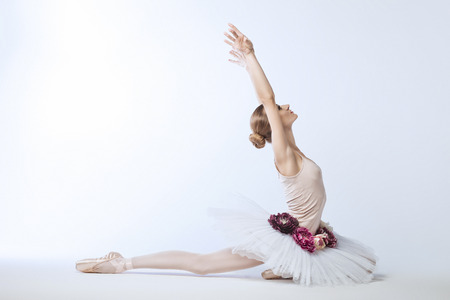 beautiful and plastic ballerina in tutu sitting on the floor, a ballet performance