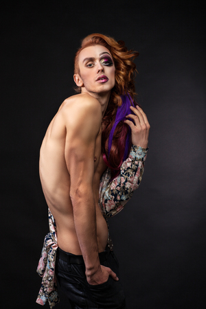 red-haired man with a naked torso and black pantsの写真素材