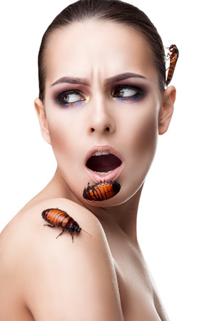 portrait of a beautiful woman with a beetle on her faceの写真素材