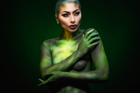 a beautiful young girl and painted body art in the style of the serpentの写真素材