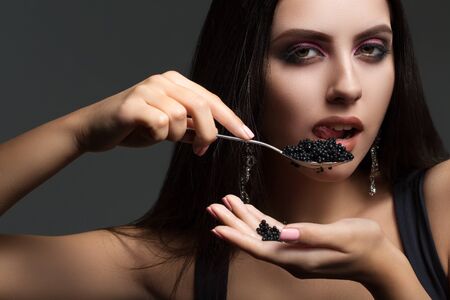 burning brunette with long hair holding a black caviarの写真素材