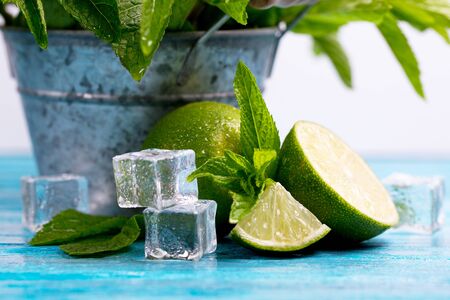 sliced lime with mint stands on a blue, wooden tableの写真素材