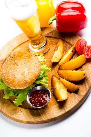 burger with chips on wooden board, delicious pub foodの写真素材