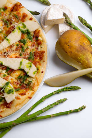 pizza with pear, cheese and asparagus. appetizing and juicy pizza on a white backgroundの写真素材