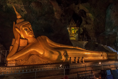 Phang Nga, Thailand - January, 25th, 2014: S Golden statue of Reclining Buddha in buddhist cave temple in Wat Tham Suwankhuha cave (Monkey Cave) In Phang Nga, Thailand.のeditorial素材
