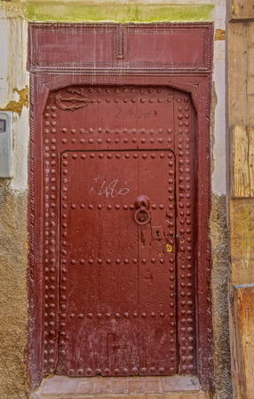 Old wooden intricately carved, studded door and door-frame,of a traditional Moroccan house in Fes, Moroccoの写真素材