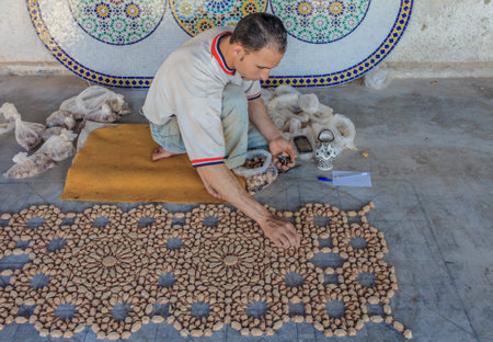 Fes, Morocco - May 11, 2013: Moroccan mozaic artist at work in a pottery shopのeditorial素材