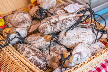 Sausage in a basket on a market stand covered with a traditional red checkered cloth in the Old Town, Vieille Ville in Nice, French Riviera, Franceの写真素材