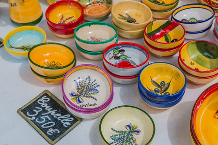 Colorful souvenir pottery dishes made of ceramics at a market stall at the Cours Saleya, famous market in Nice, that is known for hand made gifts, flowers and antiquesの写真素材