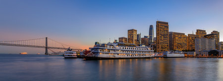 San Francisco, USA - November 27, 2017: Panoramic view of Embarcadero Buildings, decorated for Christmas, San Francisco Belle boat, Bay Bridge and downtown from famous wooden Pier 7 at sunsetのeditorial素材