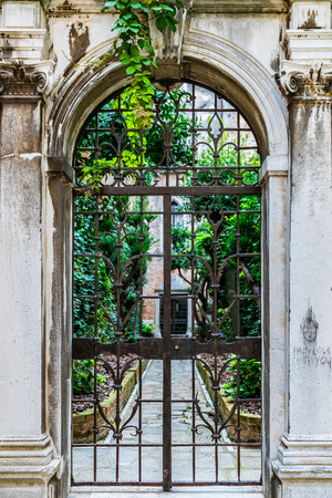 Traditional ornate metal gate in a narrow street in Venice Italyの写真素材