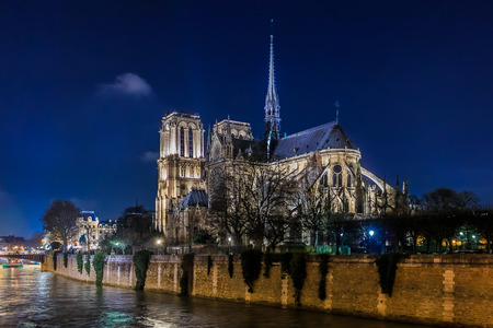 View over the river Seine onto illuminatred back side of Notre Dame de Paris Cathedral at night in, the world famous Gothic Roman Catholic cathedral in Paris, Franceの写真素材