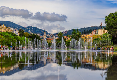 Nice, France - May 24, 2018: Reflecting fountain on Promenade du Paillon, surrounded by beautiful historic buildings and green urban park at Place Massena or Massena squareのeditorial素材