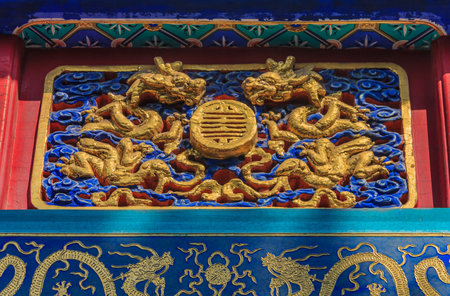 Ornate carved and painted beam and rafters with traditional Chinese golden dragon designs in Buddhist Yong'An (Temple of Everlasting Peace) in Beihai Park, Beijing, Chinaのeditorial素材