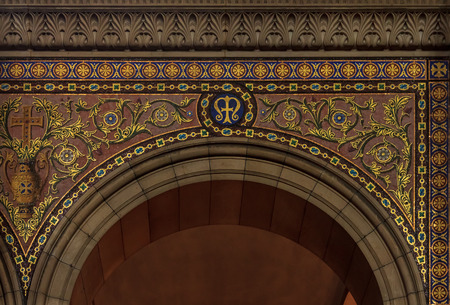 Ornate archway decorated with golden tile in floral patterns with a cross and a letter M in the middle in Cathedrale La Major or Marseille Cathedral, a Roman Catholic cathedral in Marseille, Franceの写真素材