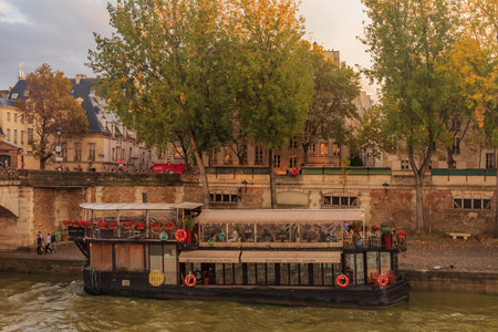 Paris, France - October 26, 2013: View onto the Seine and the floating boat restaurant La Nouvelle Seine near the Notre Dame de Paris cathedral around sunsetのeditorial素材
