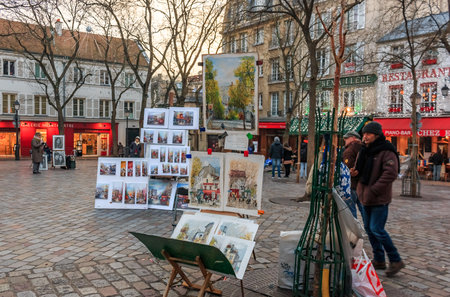 Artists awaiting customers amongst easels and artwork set up in Place du Tertre in Montmartre Paris, Franceのeditorial素材
