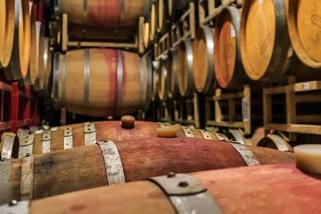 Wine barrels stacked in an old cellar at a winery in Sonoma, USAの写真素材