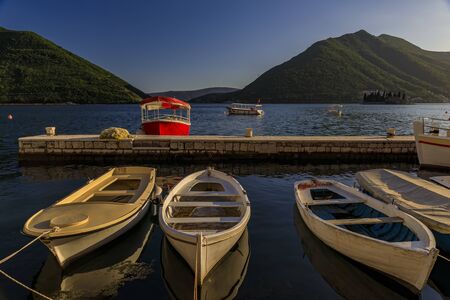 Scenic view of boats docked in the postcard perfect town of Perast in Kotor Bay at sunset with mountains in the background in the summer, Montenegroの写真素材