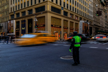 New York USA - Yellow taxi cabs and other blurred cars speed past people crowds and a traffic...