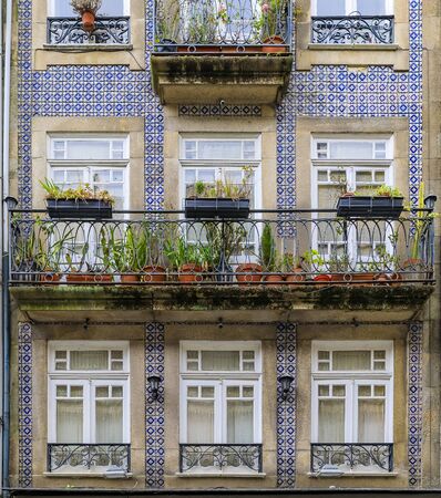 Facades of traditional houses decorated with ornate Portuguese azulejo tiles in the streets of Porto, Portugalの写真素材