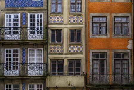 Facades of traditional houses decorated with ornate Portuguese azulejo tiles in the streets of Porto, Portugalの写真素材