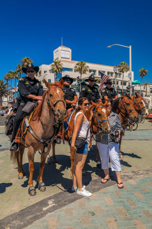 Huntington Beach, USA - July 03, 2017: Equestrian police officers from Huntington Beach and Santa Ana Police Departments interacting with touristsのeditorial素材