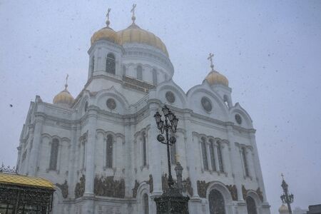 Facade of the famous orthodox Cathedral Of Christ the Savior blurred in a snow storm with snowflakes in the air in Moscow, Russiaの写真素材