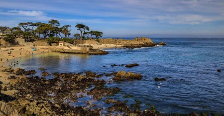 Panoramic view of the Pacific Ocean waves crashing on the cliffs of the rugged Northern California coastline in Monterey
