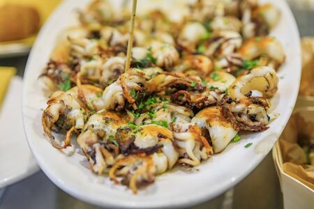 Traditional Italian street food in Venice - fried baby calamari on display on a plate at a stall, Italyの写真素材