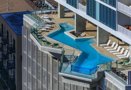 View of the bright blue water in a modern luxury pool on an outdoor terrace in a residential...