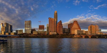 Panorama with downtown high-rises reflecting sunset golden hour light viewed across Lady Bird Lake or Town Lake on Colorado River in Austin, Texas USAの写真素材