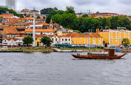 Porto, Portugal - May 30, 2018: View across the Douro onto famous Portuguese wine cellars and tourist boats that were used for transporting port wineのeditorial素材