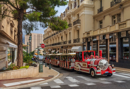 Monte Carlo, Monaco - October 13, 2013: Red and white trackless tourist train of Monaco driving through streets of the city center near Casino Royalのeditorial素材