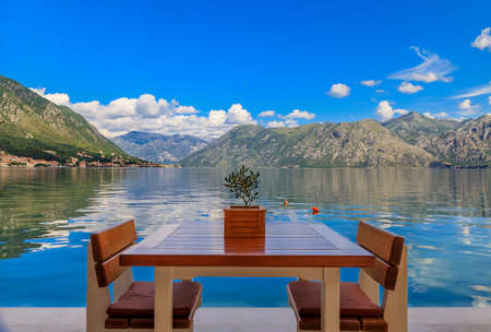 Waterfront table at a restaurant with a view of Kotor Bay of Kotor Bay or Boka Kotorska in the...