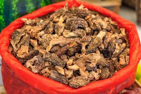 Bag of dried morel or morchella mushrooms for sale in at an outdoor farmers market in old town...