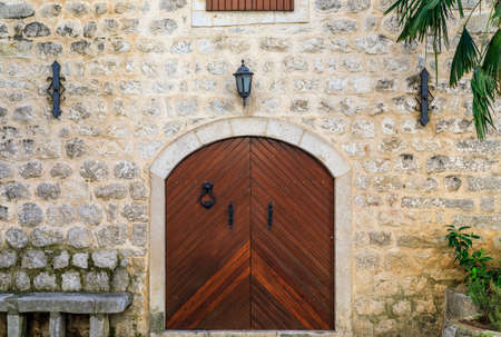 Picturesque wooden gate of an old stone house in the well preserved medieval Old town Kotor, Montenegro in the Balkansの写真素材
