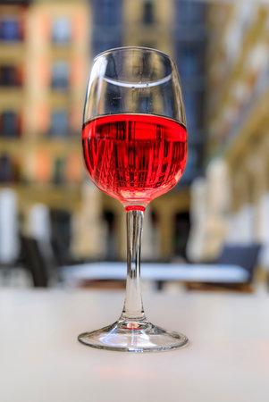 Glass of Spanish rose or rosado with a blurred building background in a restaurant on a square in the old town or Casco Viejo of Pamplona, Spainの写真素材