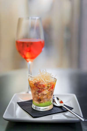 Artisanal seafood ceviche with guacamole pintxos or tapas with a blurred glass of Spanish rose or...