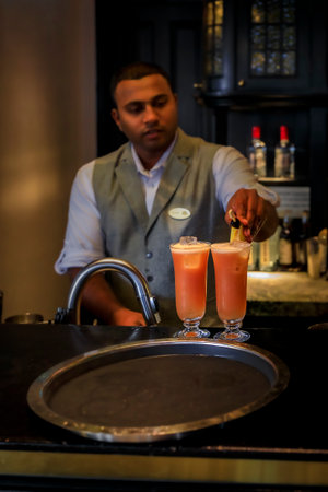 Singapore - September 08, 2019: Server preparing the Singapore Sling cocktail at the iconic Raffles Hotel Long Bar, famous for inventing itのeditorial素材