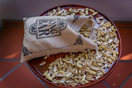 Singapore - September 08, 2019: Branded bag of peanuts at The Long Bar, the iconic bar at the Raffles Hotel, famous for inventing the Singapore Slingのeditorial素材