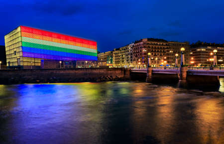 San Sebastian skyline with Kursaal Congress Centre and Auditorium conference center in Spain, decorated with an LGBT Pride rainbow flag at sunsetの写真素材