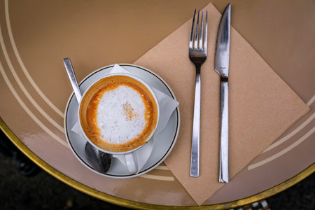 Cup of cappuccino at breakfast on an outdoor table at a bakery cafe in old town or Vieille Ville in...
